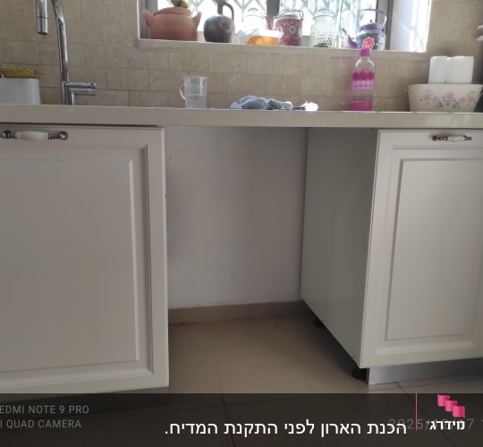 ארונות מטבח לבנים עם משטח עבודה וכיור